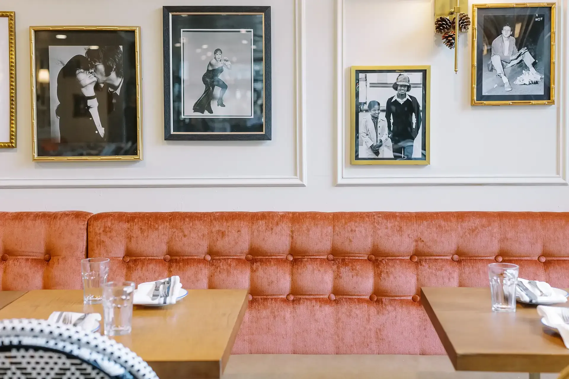 A restaurant with tables and chairs and pictures on the wall.