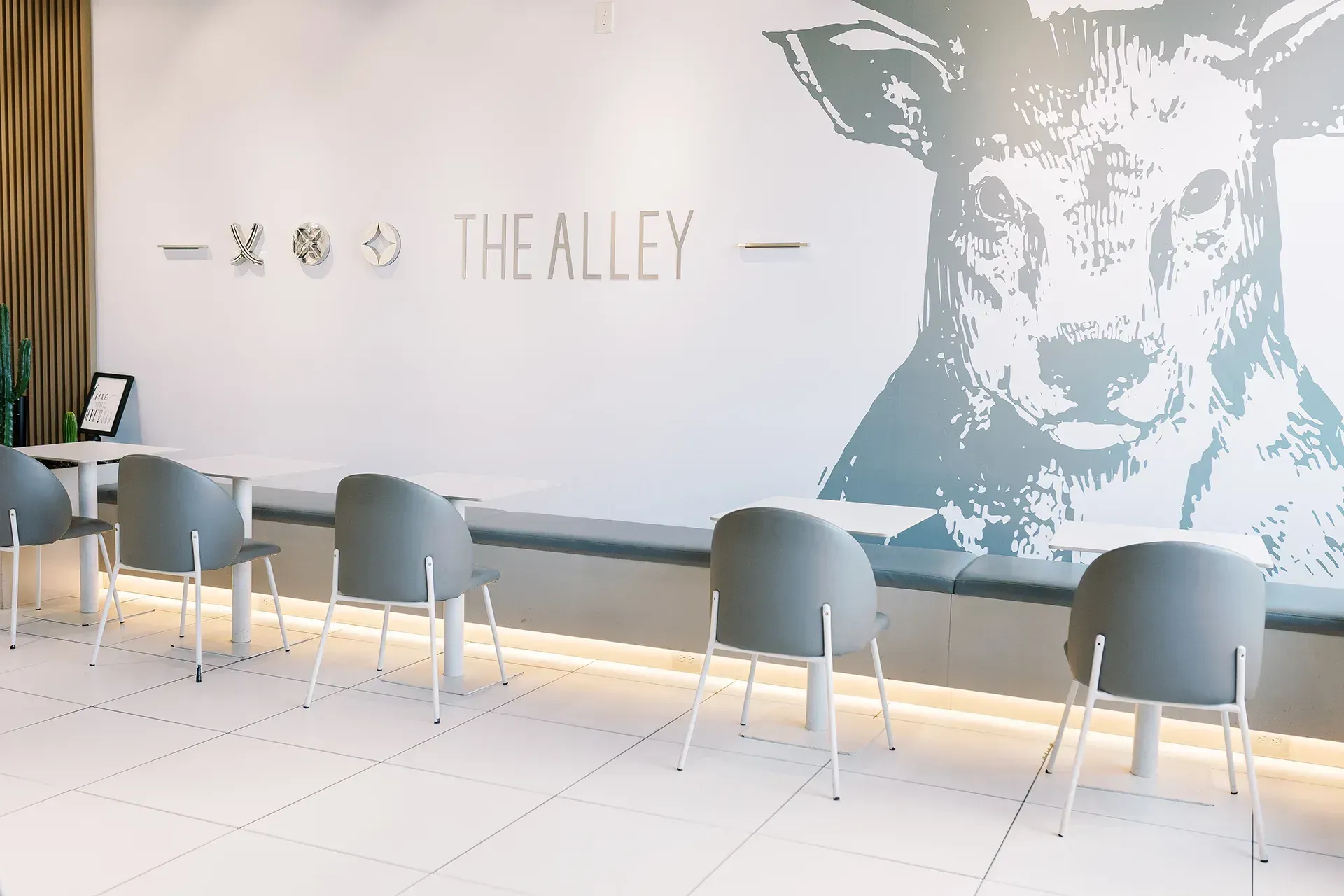 A restaurant with tables and chairs and a picture of a deer on the wall.