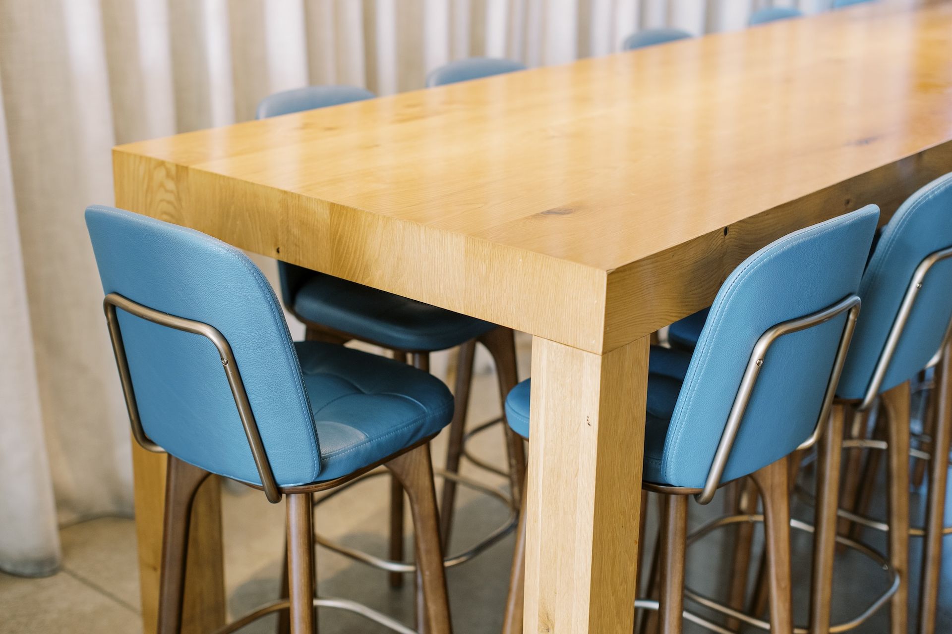 A wooden table with blue chairs around it in a room.