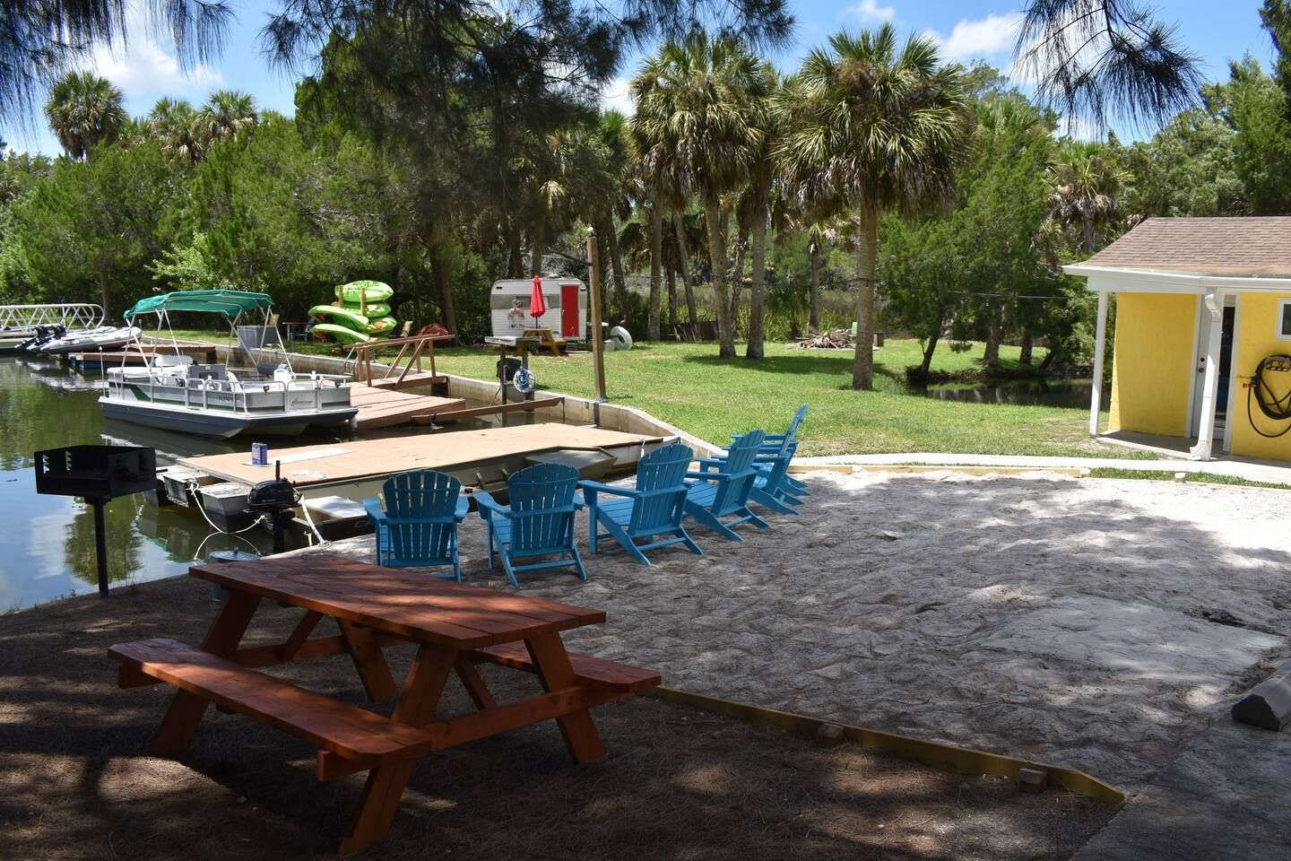 A picnic table and chairs are sitting next to a body of water.