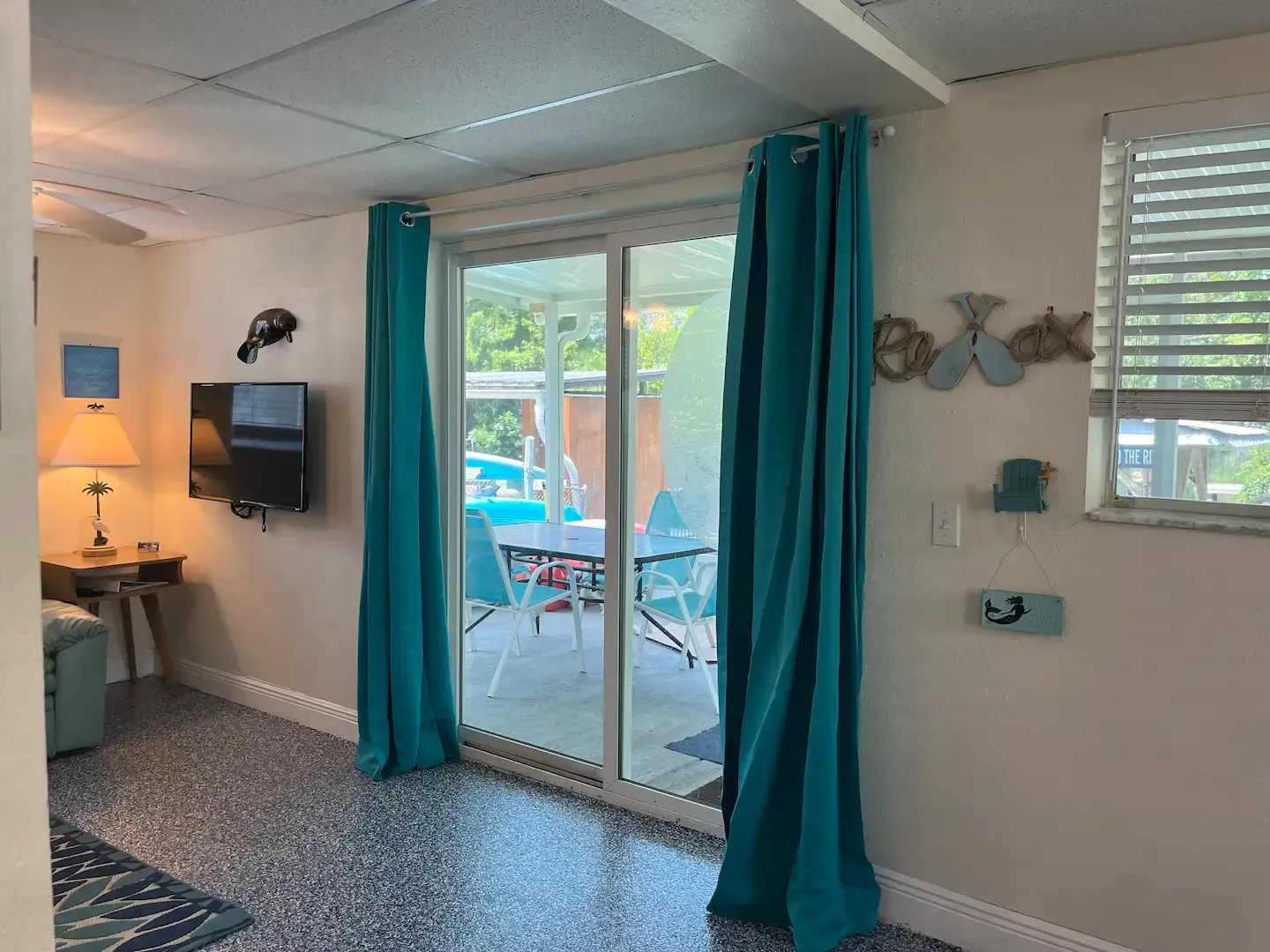 A living room with a sliding glass door and blue curtains.