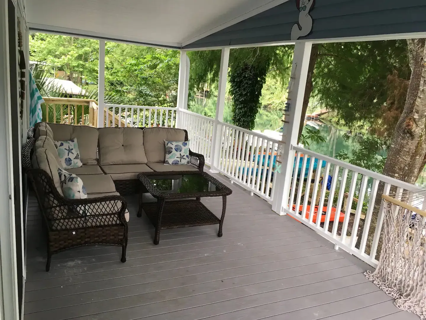 A porch with a couch , chairs , and a coffee table.
