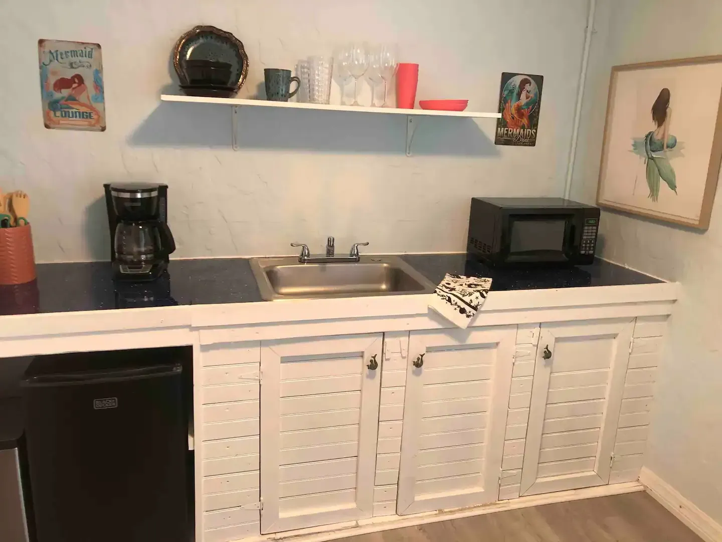 A kitchen with a sink , microwave , and refrigerator.