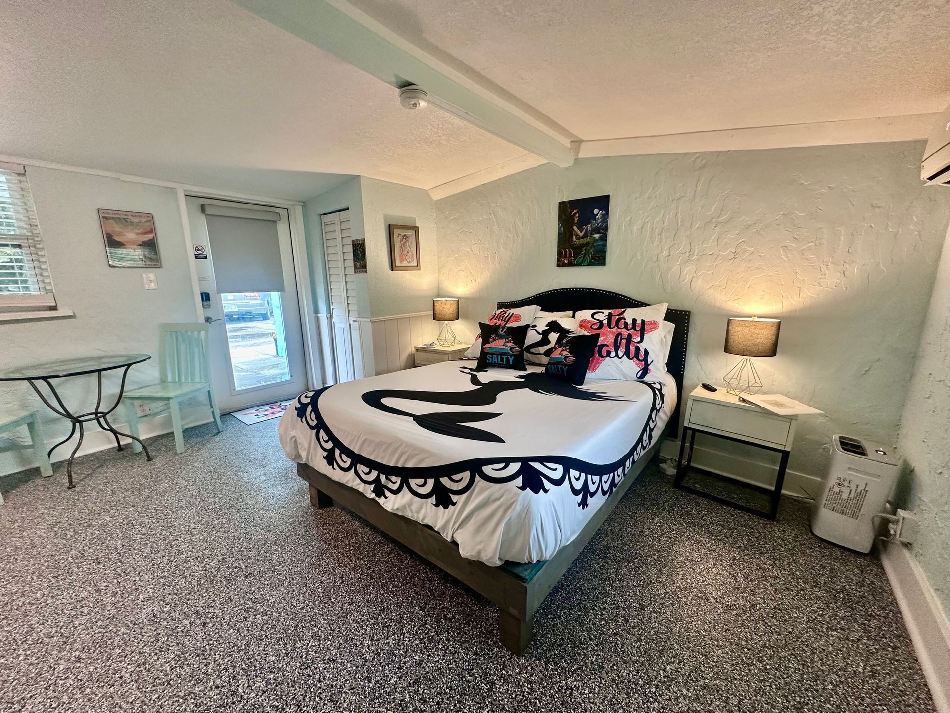A picnic table and chairs on a sandy beach next to a river.