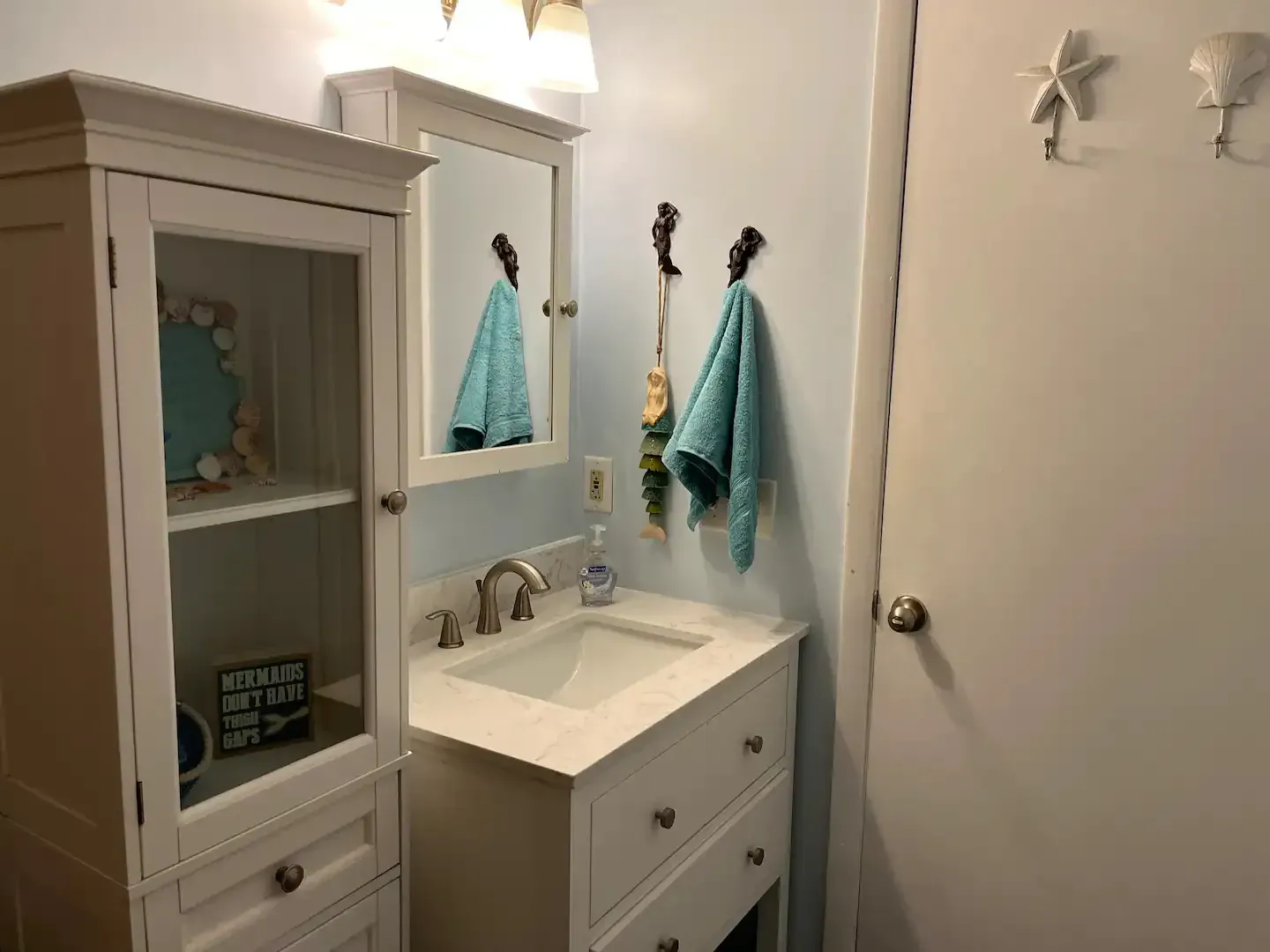 A bathroom with a sink , mirror and cabinet.