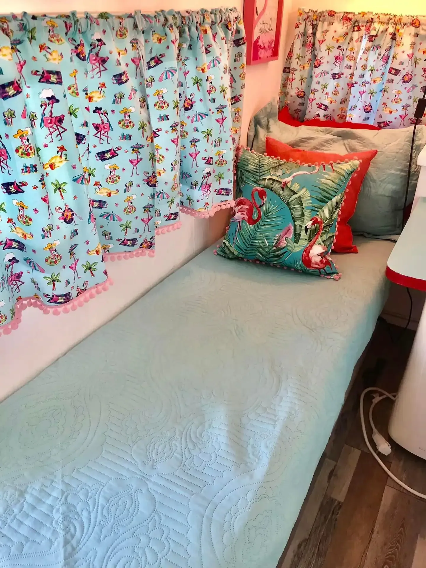 A bed with a quilt and pillows in a camper.