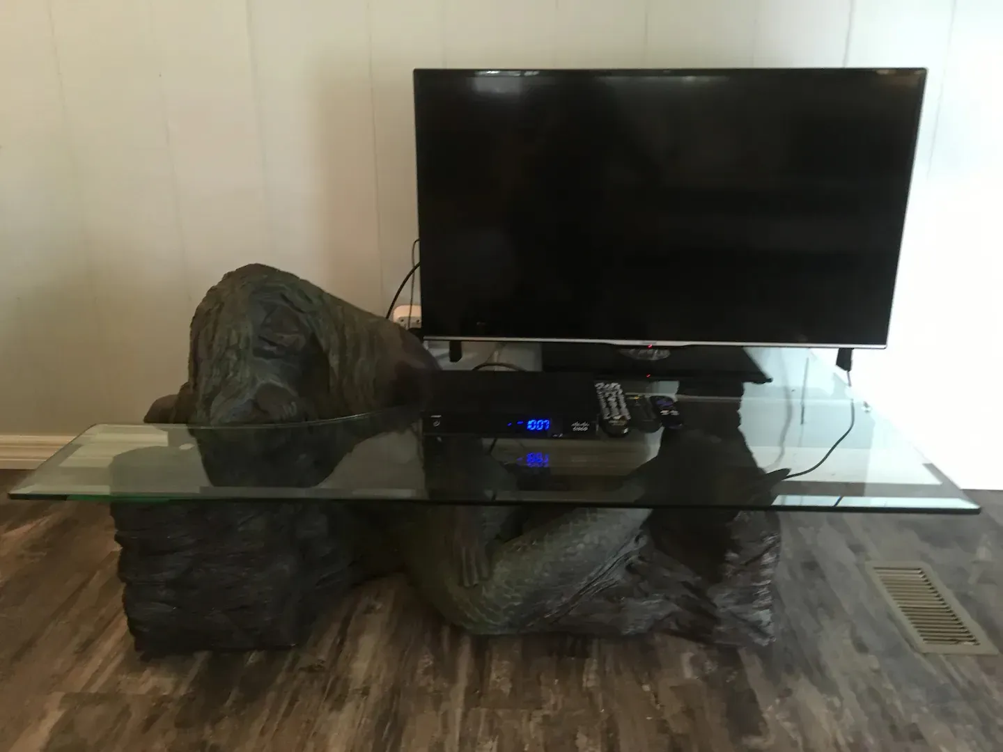 A flat screen tv is sitting on top of a glass table
