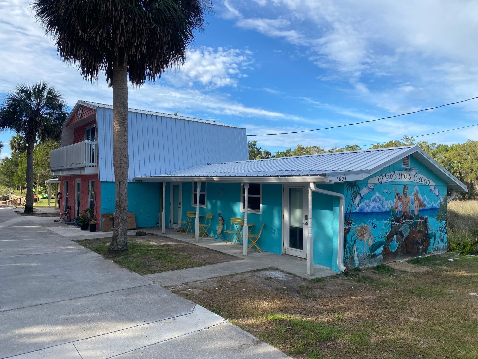 A picnic table and chairs on a sandy beach next to a river.