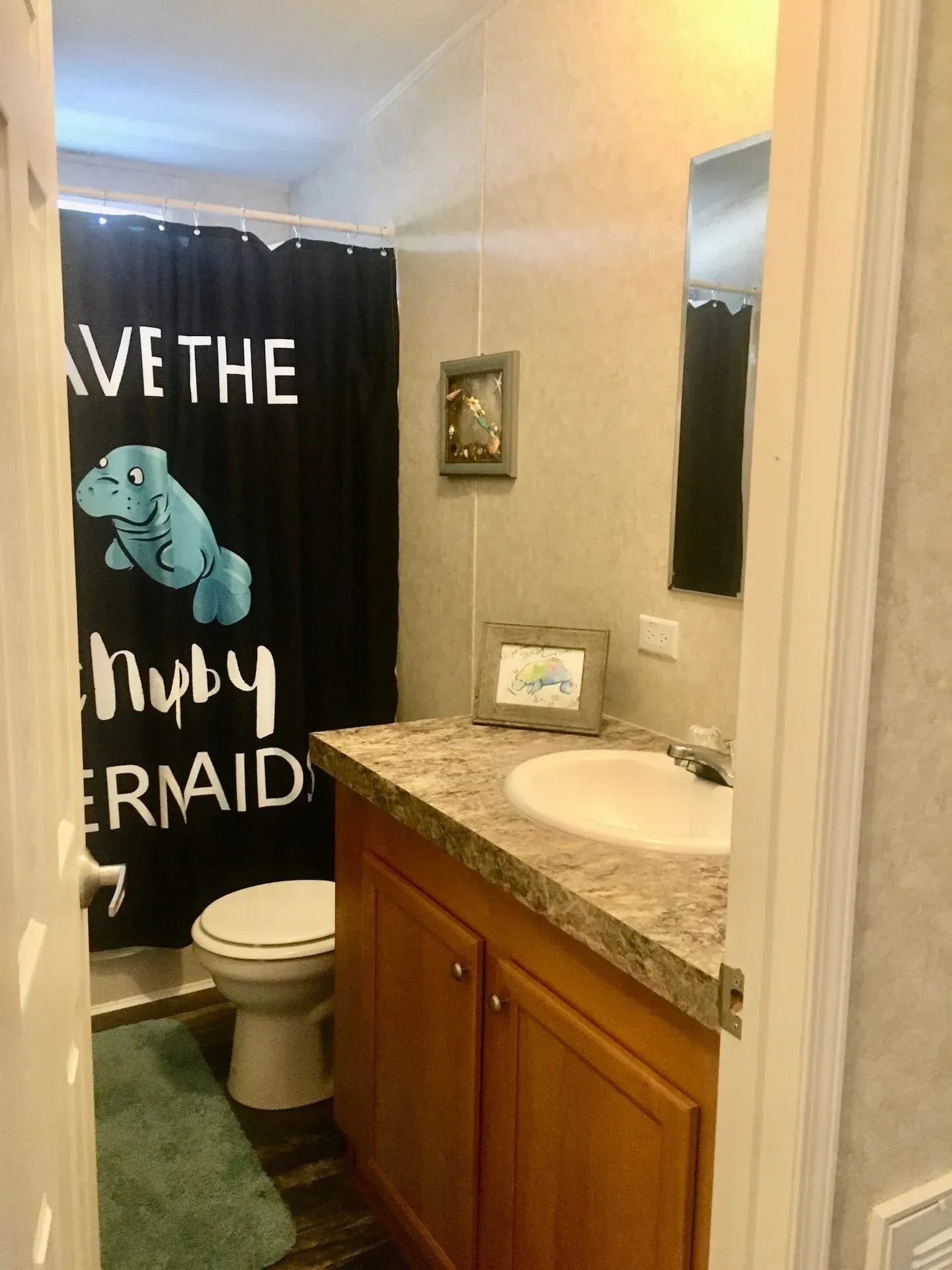 A bathroom with a shower curtain that says save the ruby mermaid