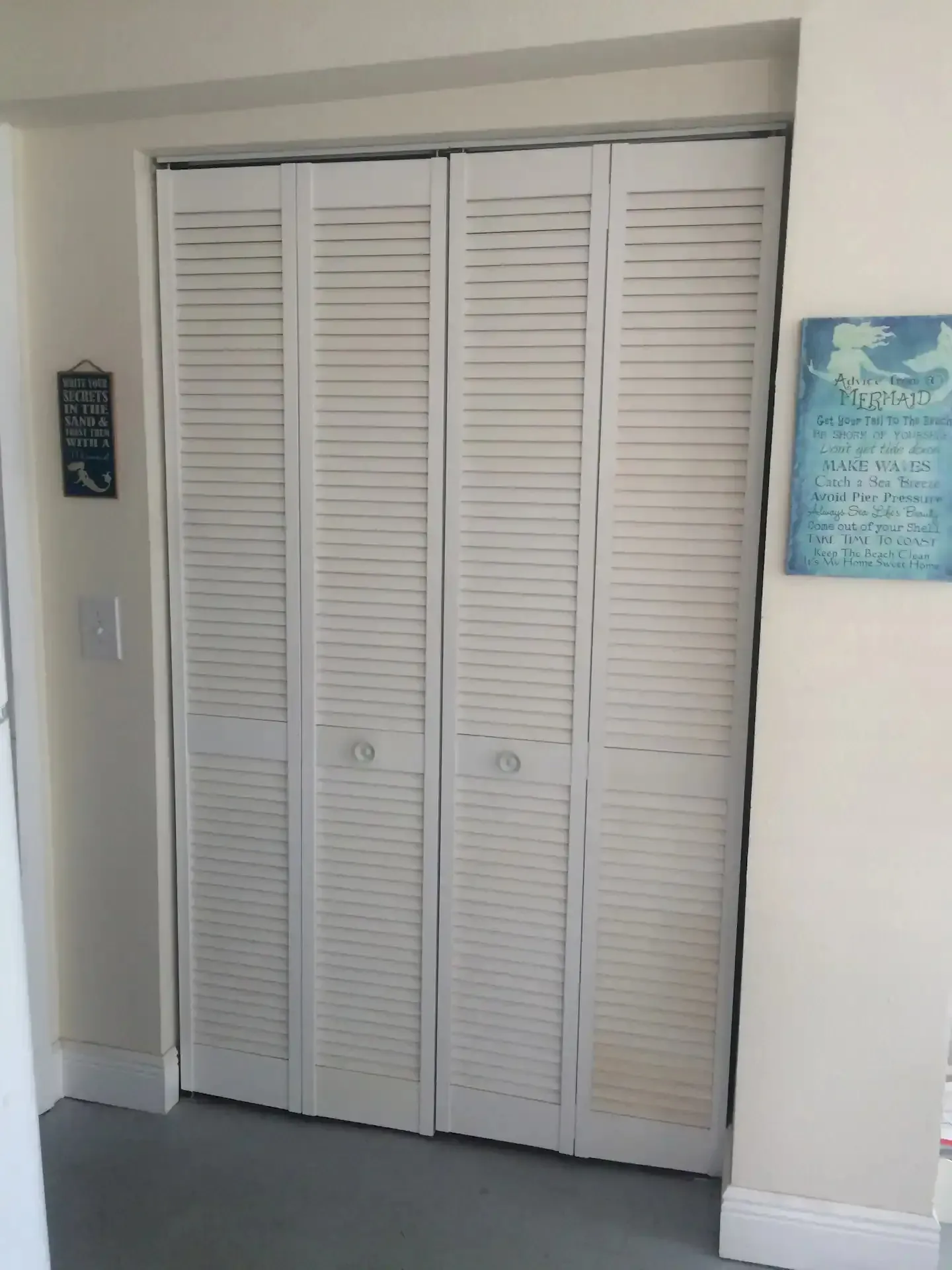 A closet with shutters and a sign on the wall