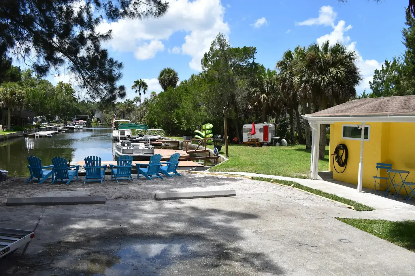 A yellow house sits next to a body of water