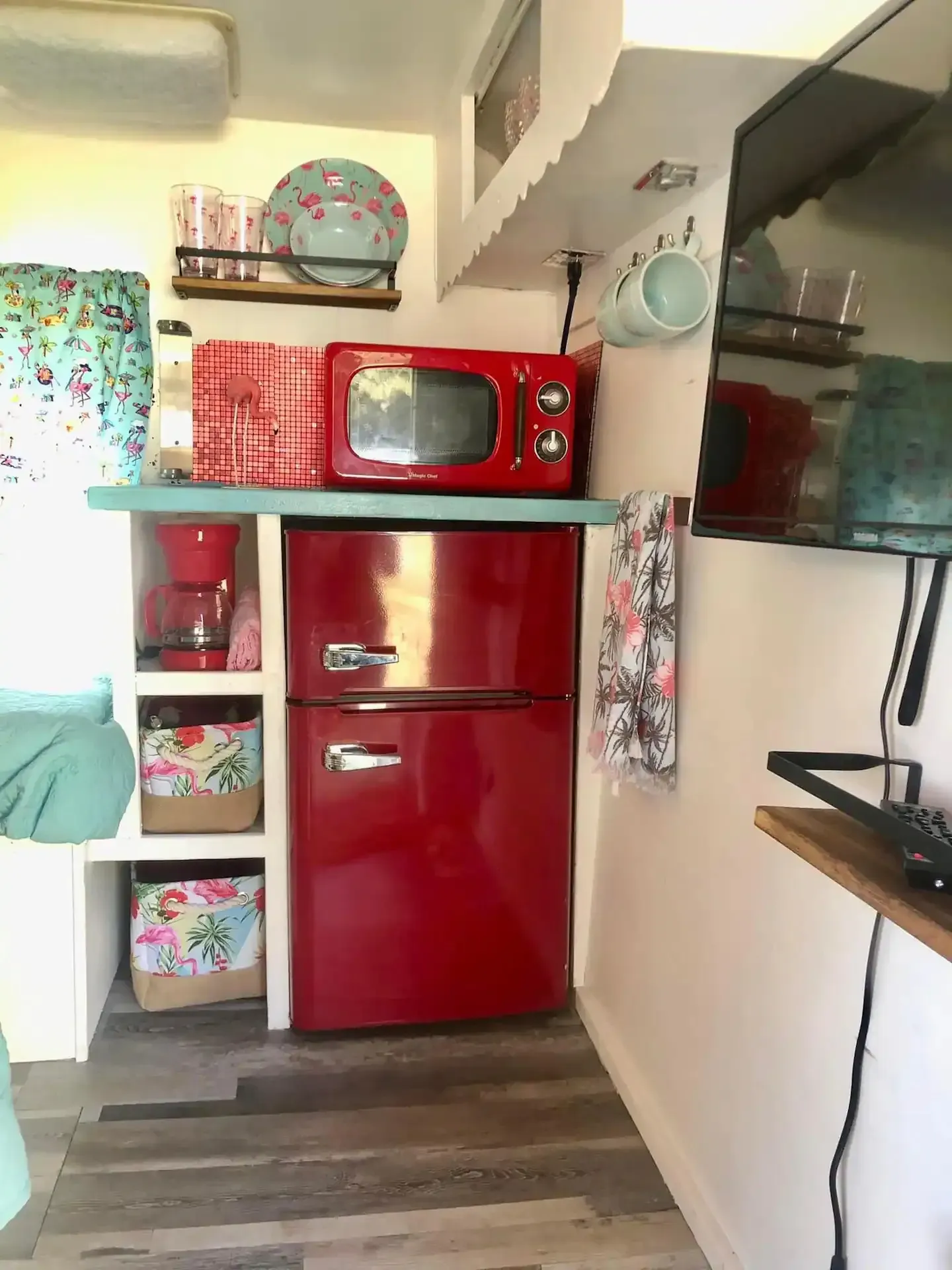 A kitchen with a red refrigerator , microwave , and sink.