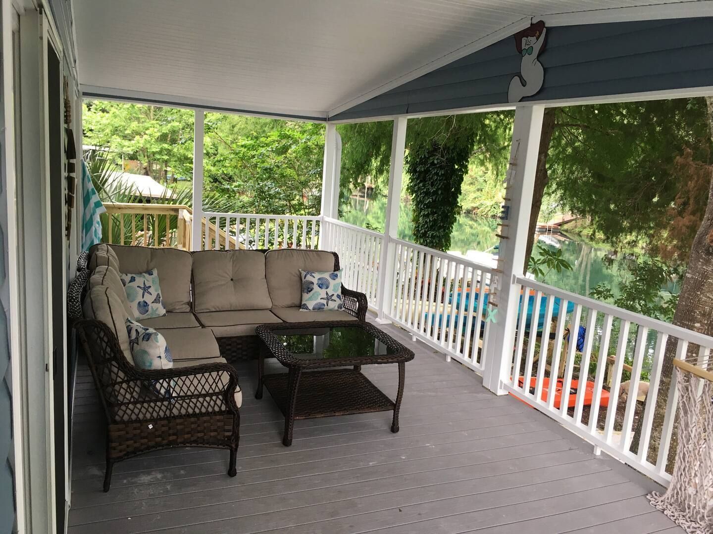 A porch with a couch and a table on it.