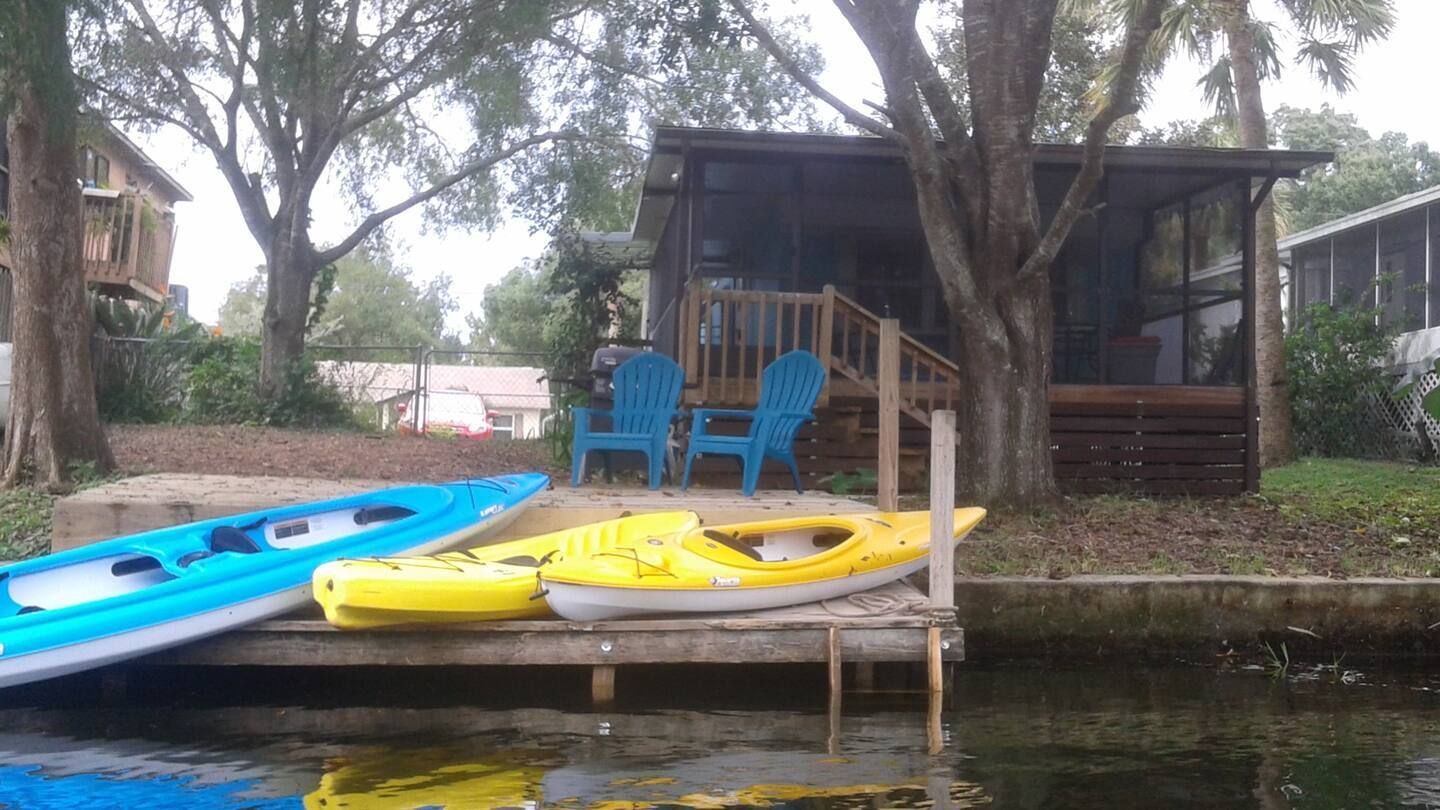 A couple of kayaks are sitting on a dock next to a house.