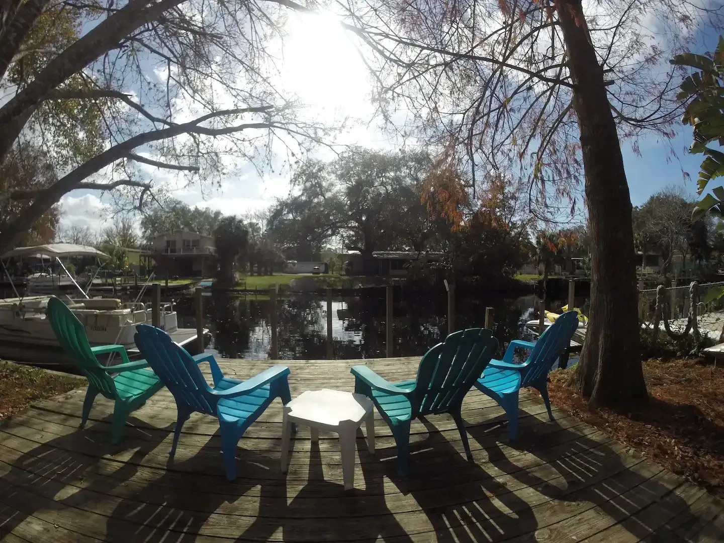 A group of blue chairs are sitting on a patio next to a body of water.