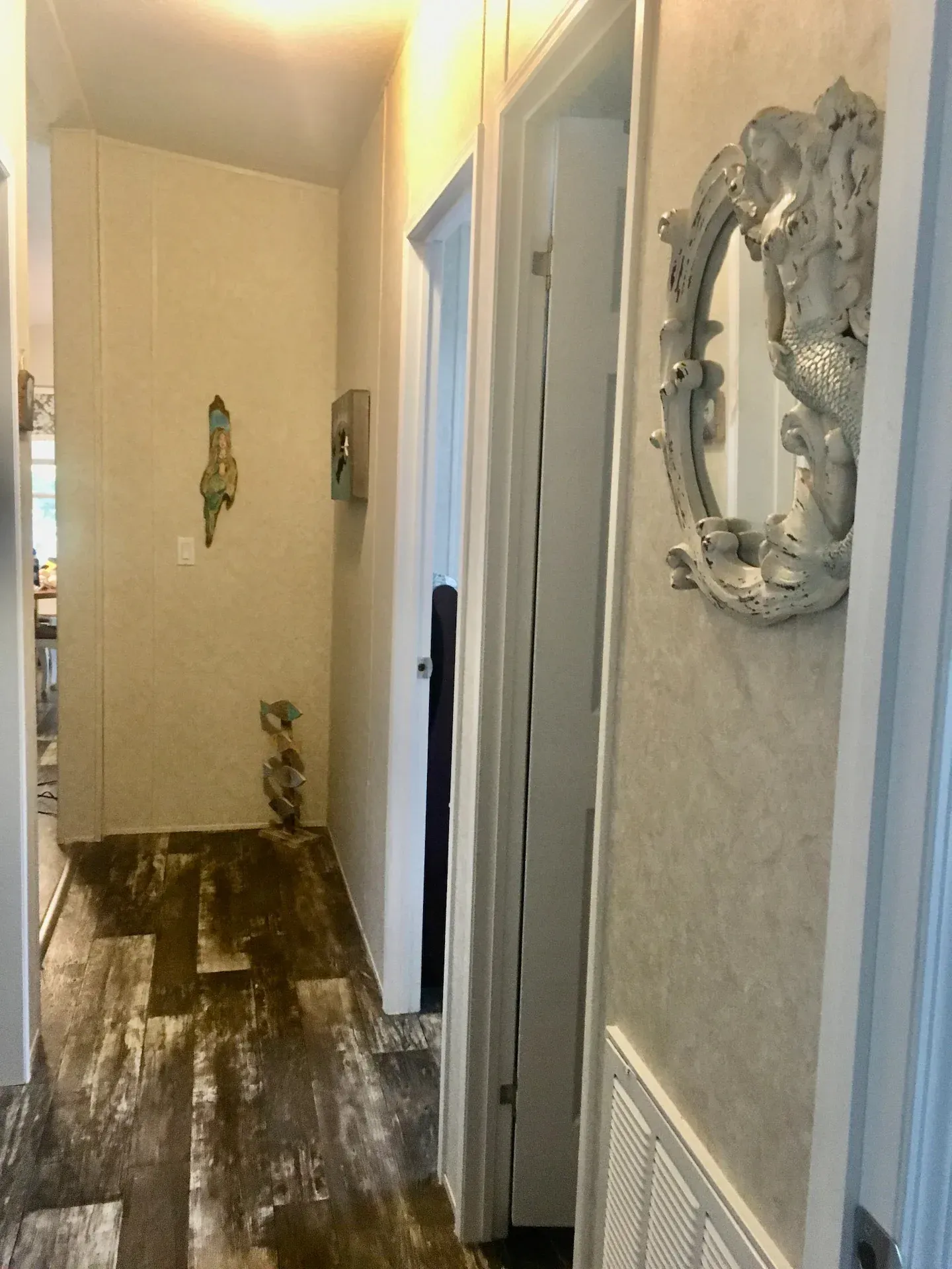 A hallway in a house with a mirror on the wall.