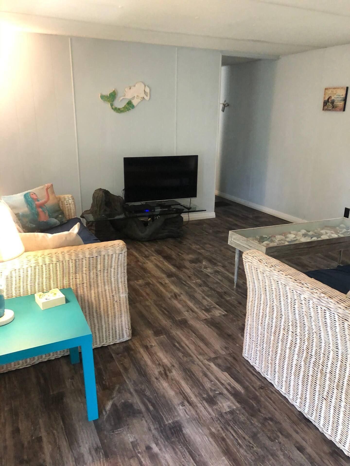 A living room with a couch , chair , table and television.