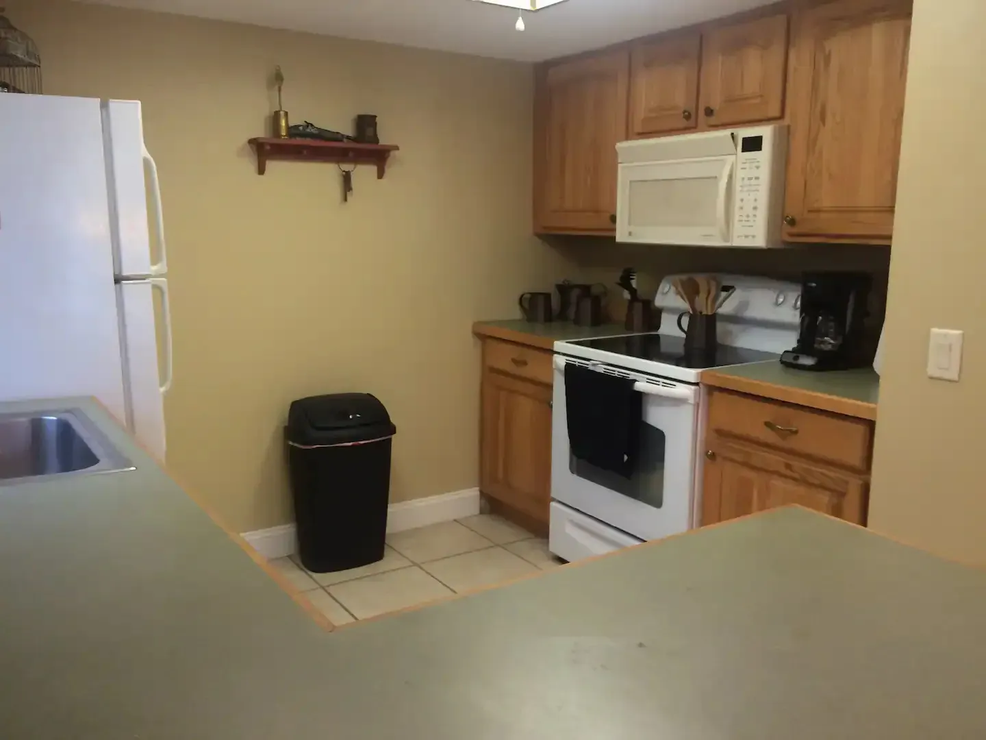 A kitchen with a stove a refrigerator and a microwave
