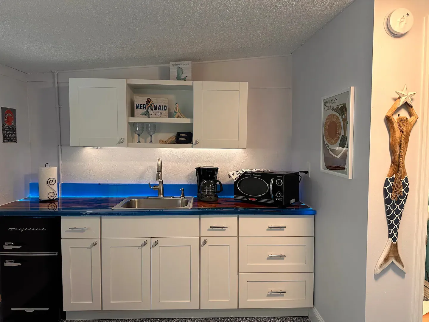 A kitchen with white cabinets and a blue counter top