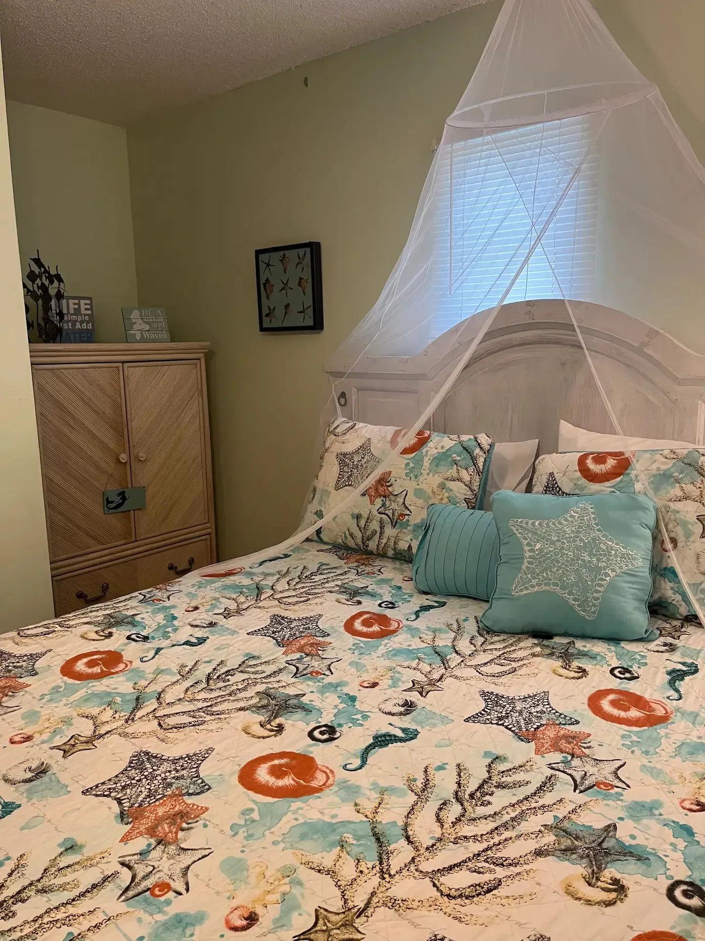 A bedroom with a bed and a mosquito net over it.