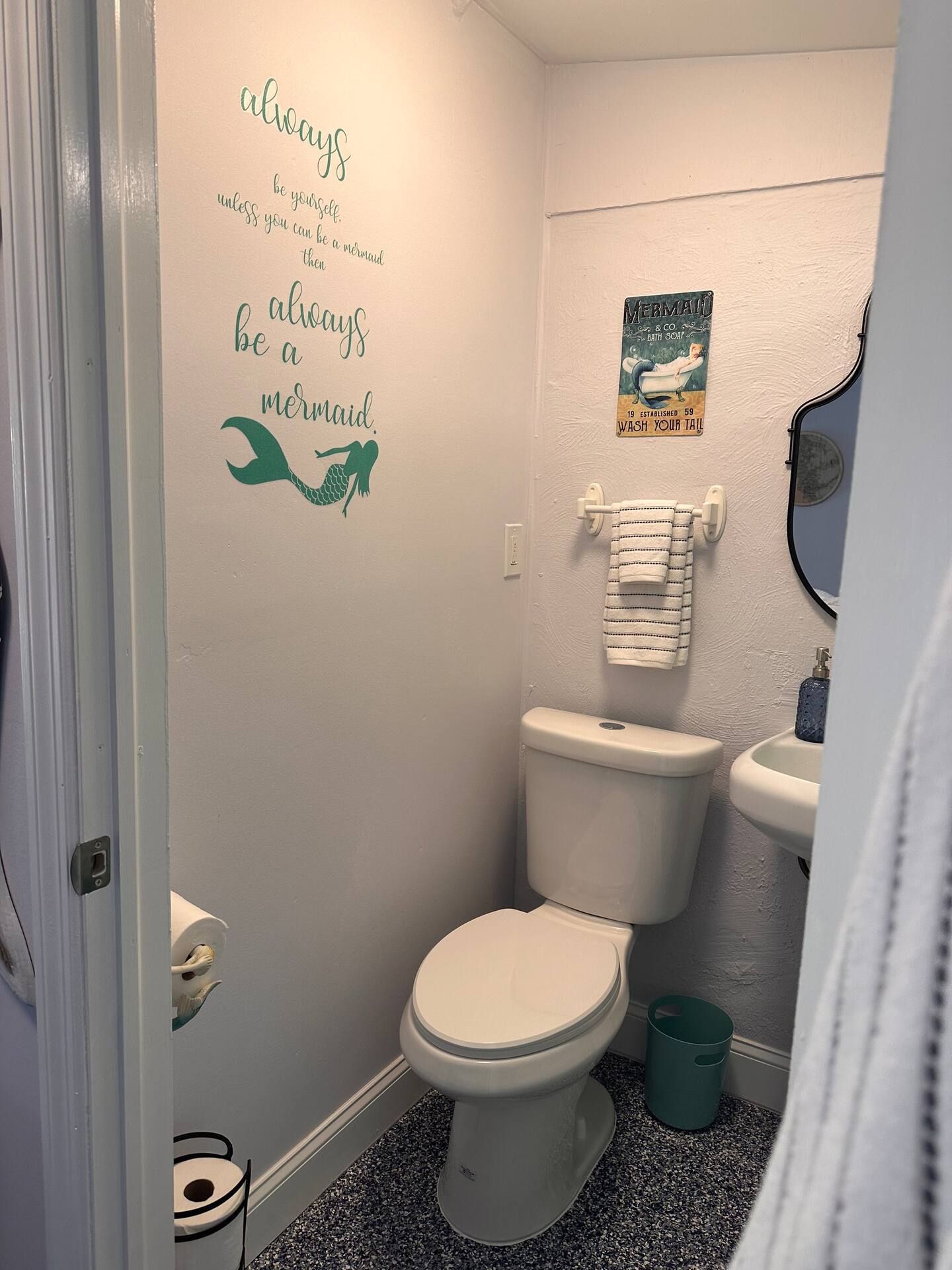 A bathroom with a toilet , sink and mirror.