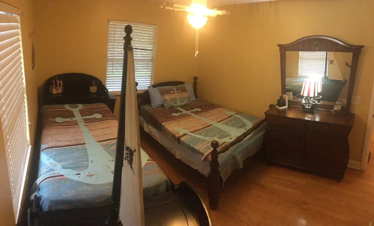 A bedroom with two beds a dresser and a mirror