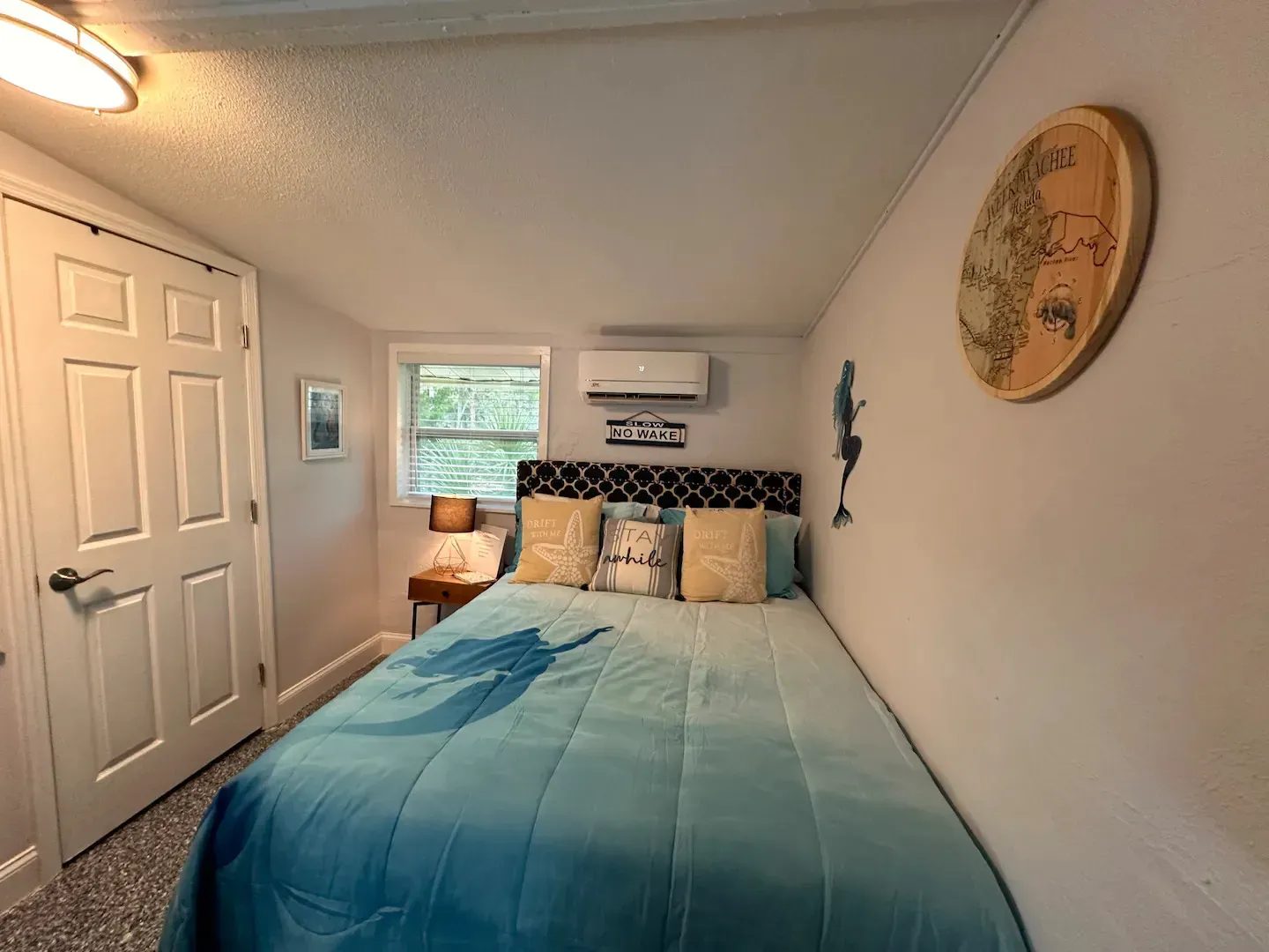 A bedroom with a bed and a clock on the wall.