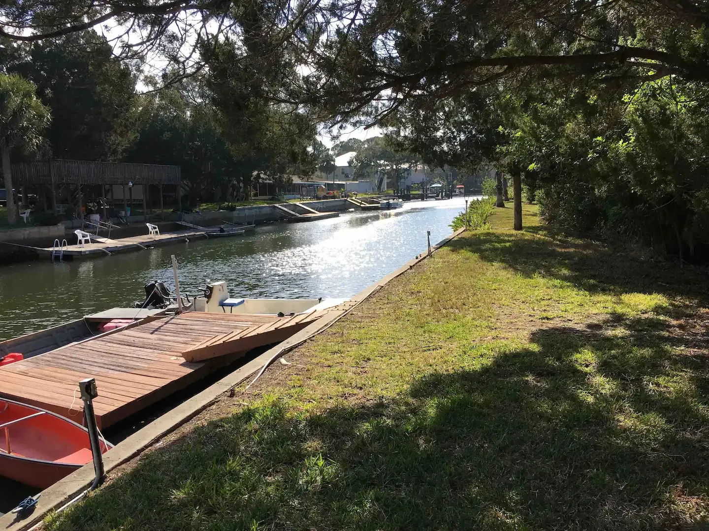 A boat is docked on a dock next to a river.
