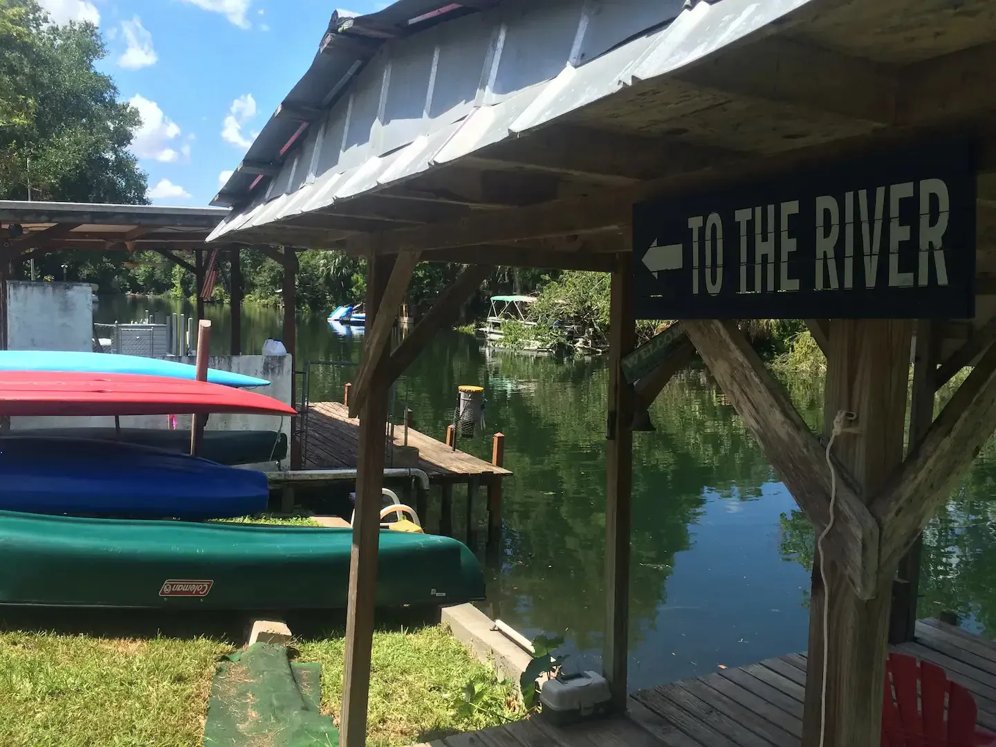A sign that says to the river is next to a dock