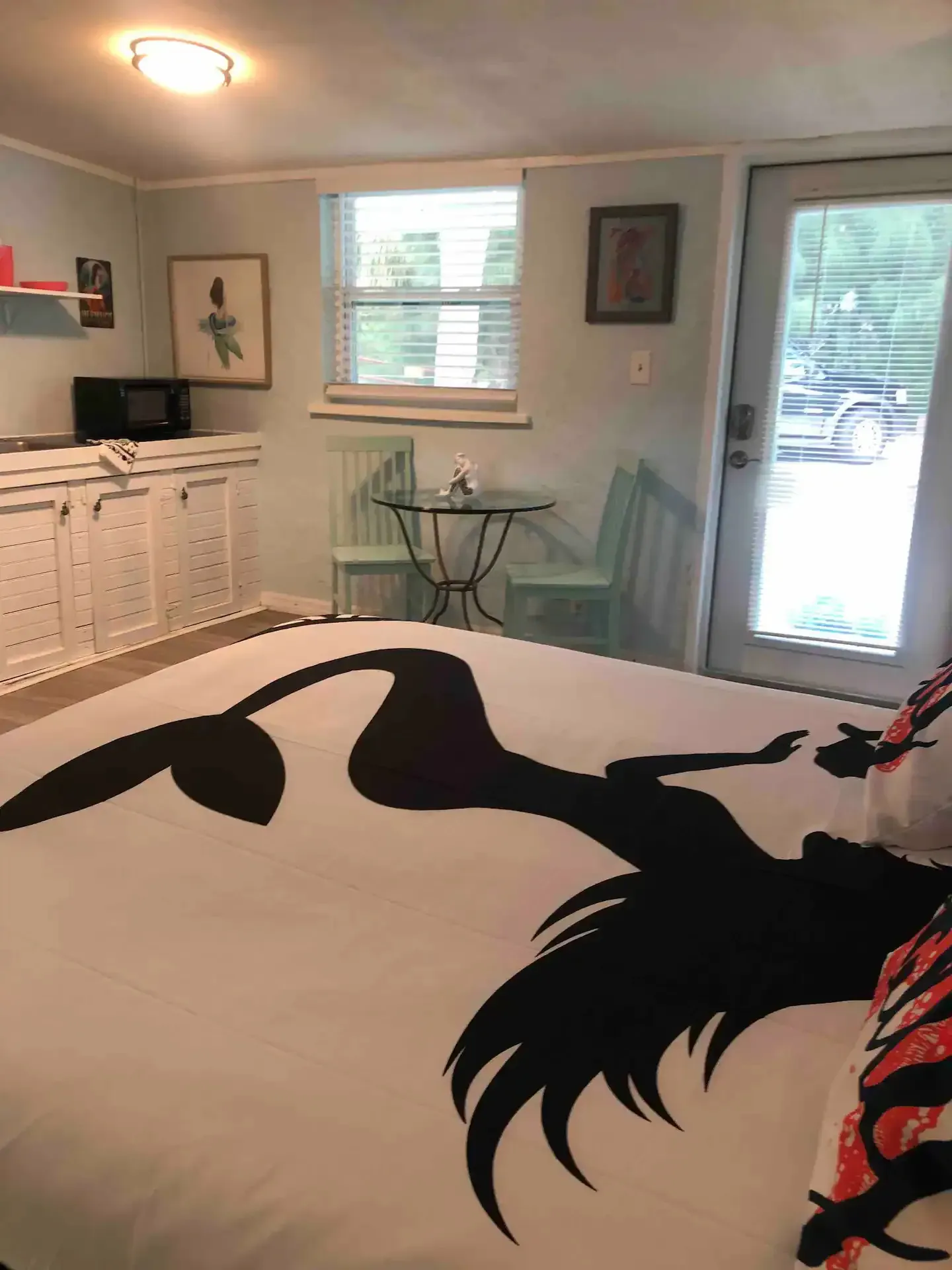 A bedroom with a bed , chairs , a table and a window.