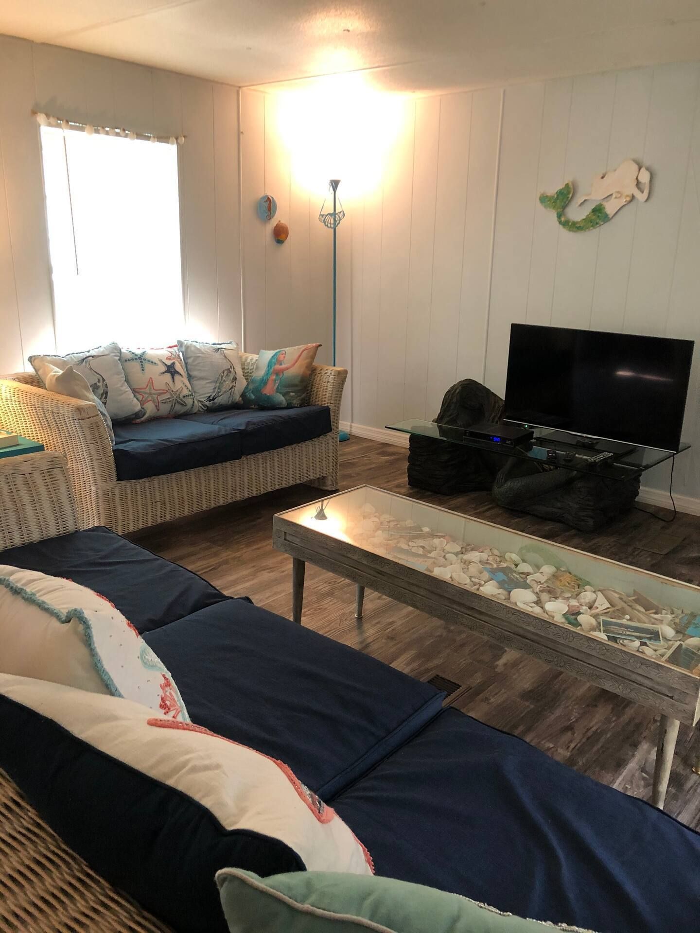 A living room with a couch , coffee table , and television.