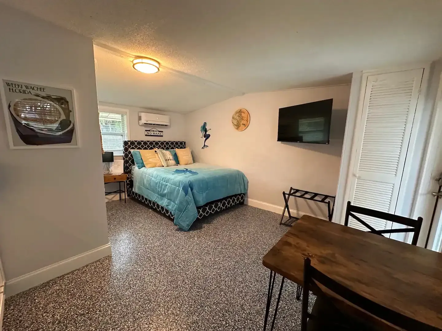 A bedroom with a bed , table , chairs and television.