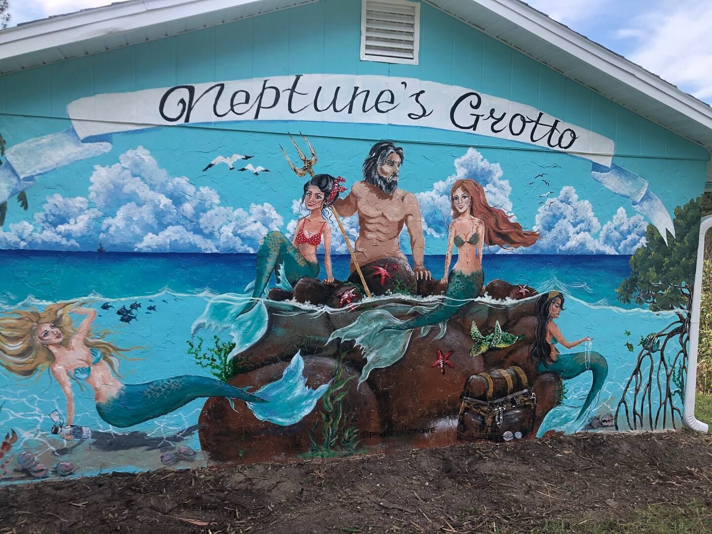 A mural on the side of a building that says neptune 's grotto