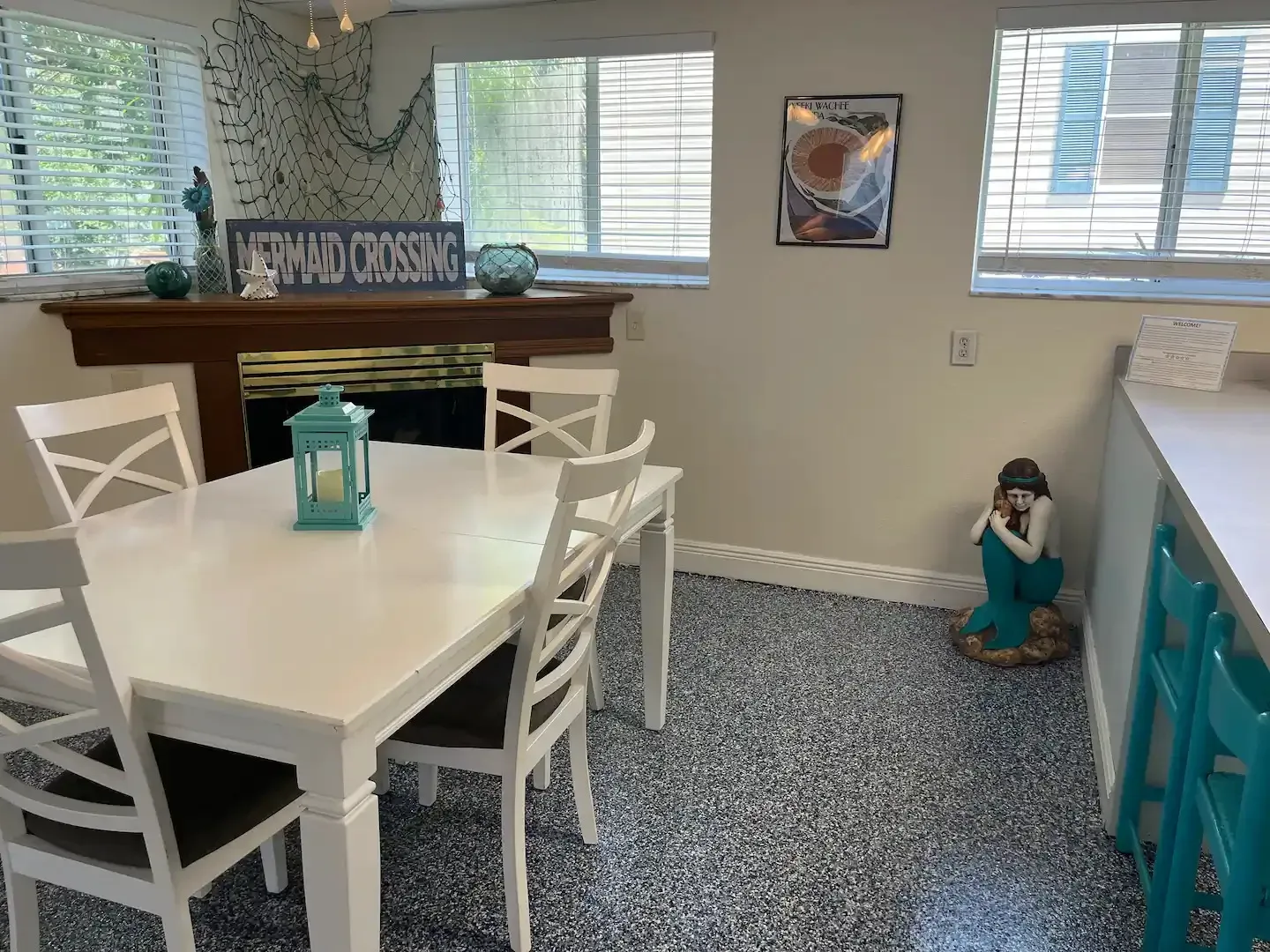 A dining room with a table and chairs and a fireplace.