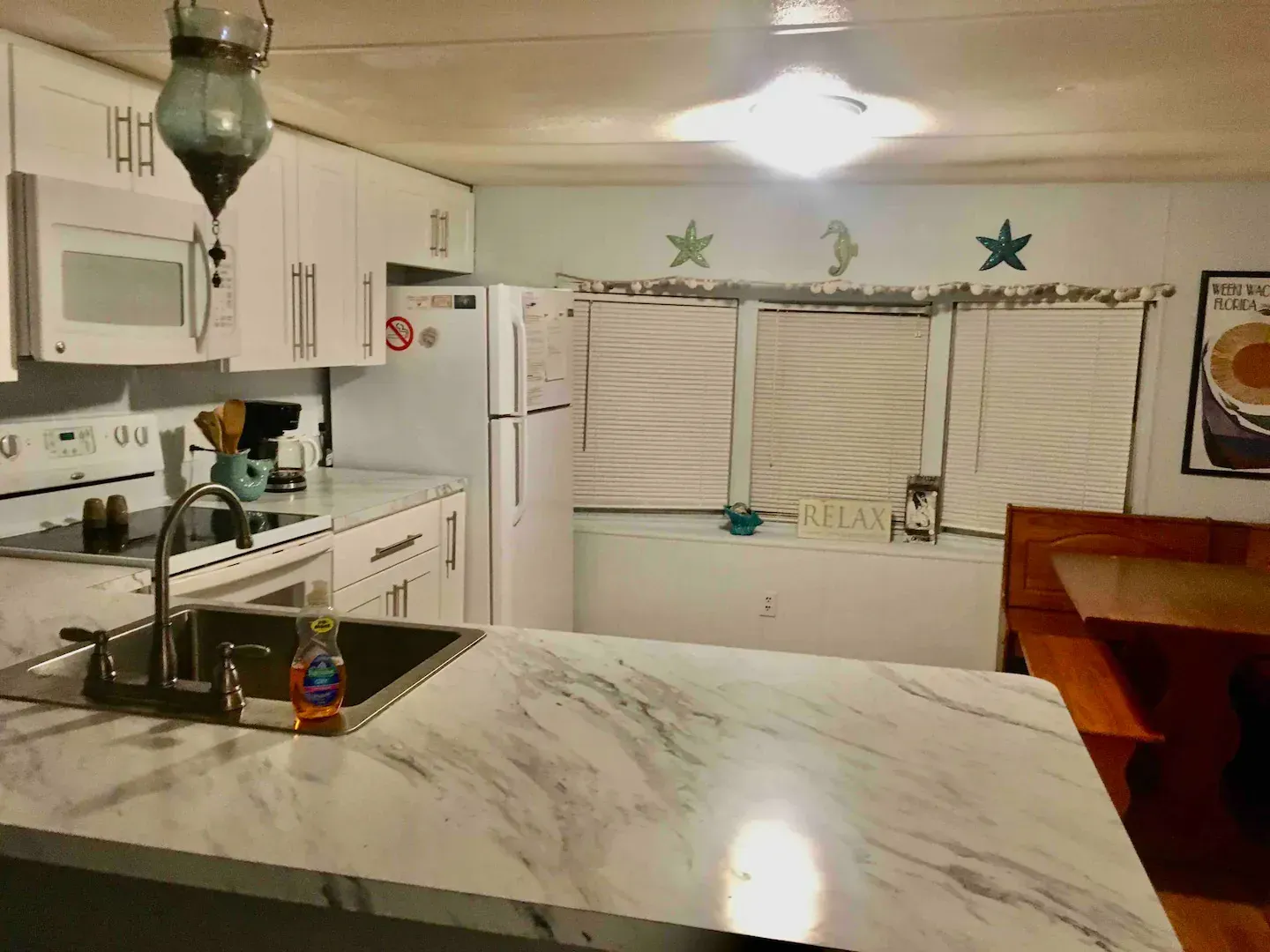 A kitchen with white cabinets and a marble counter top