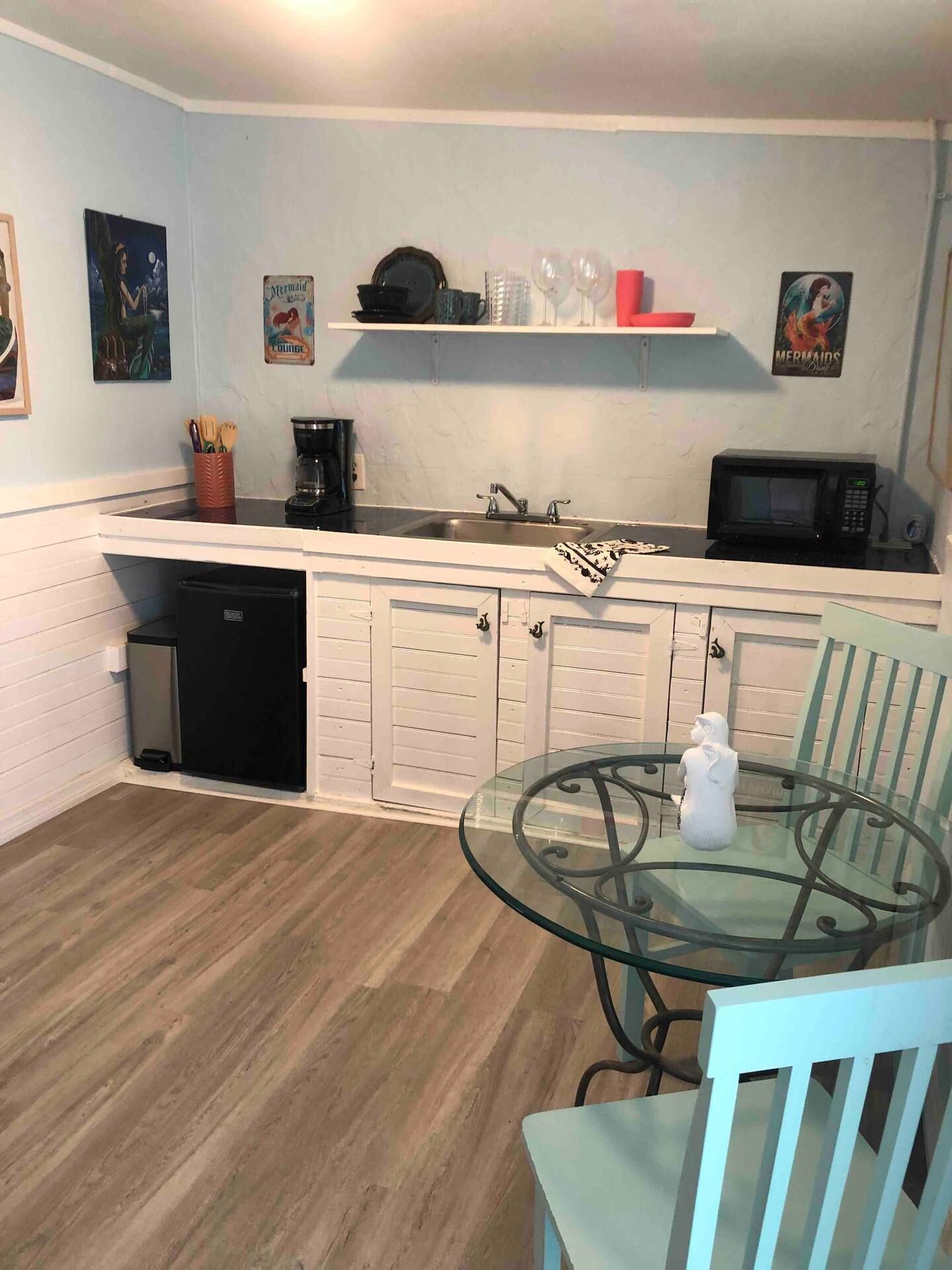 A kitchen with a table and chairs and a sink.