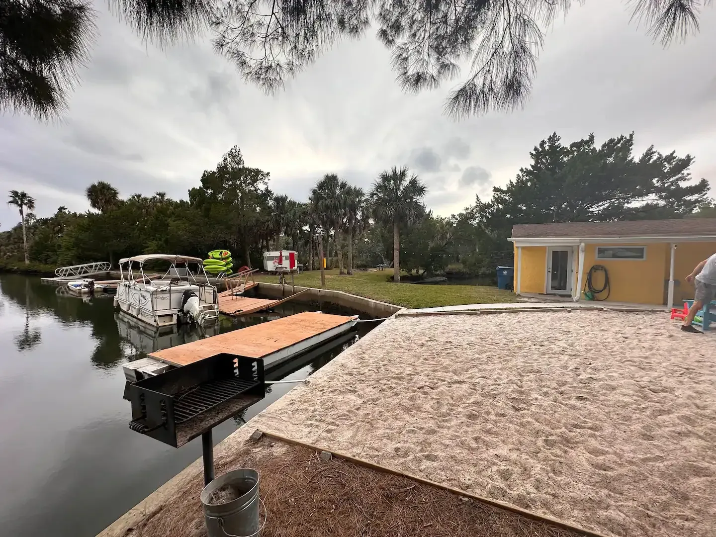 A man is working on a dock next to a body of water.