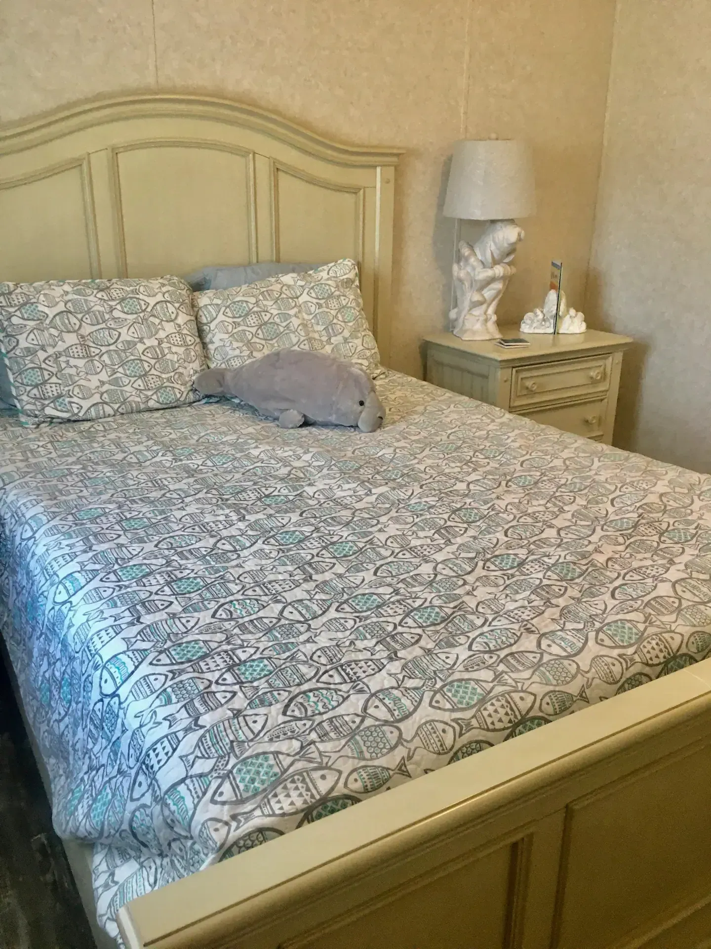 A bedroom with a bed , nightstand and lamp.