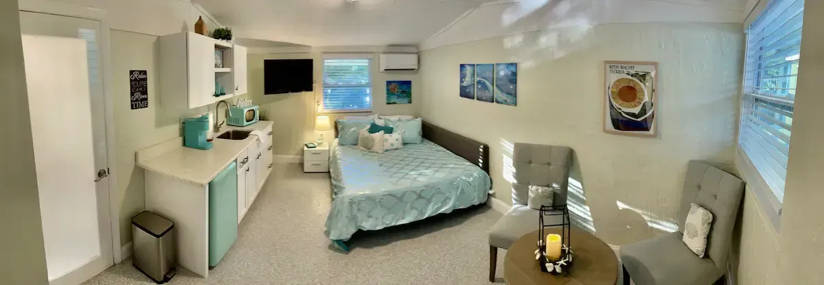 A bedroom with a bed , chair , table and television.