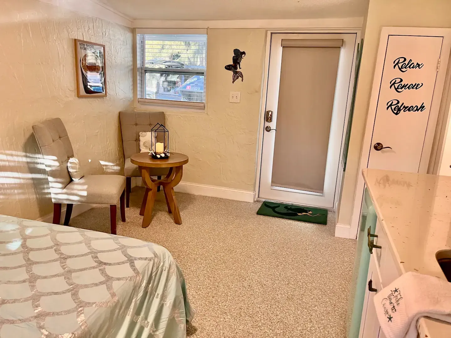 A bedroom with a bed , chair , table and door.
