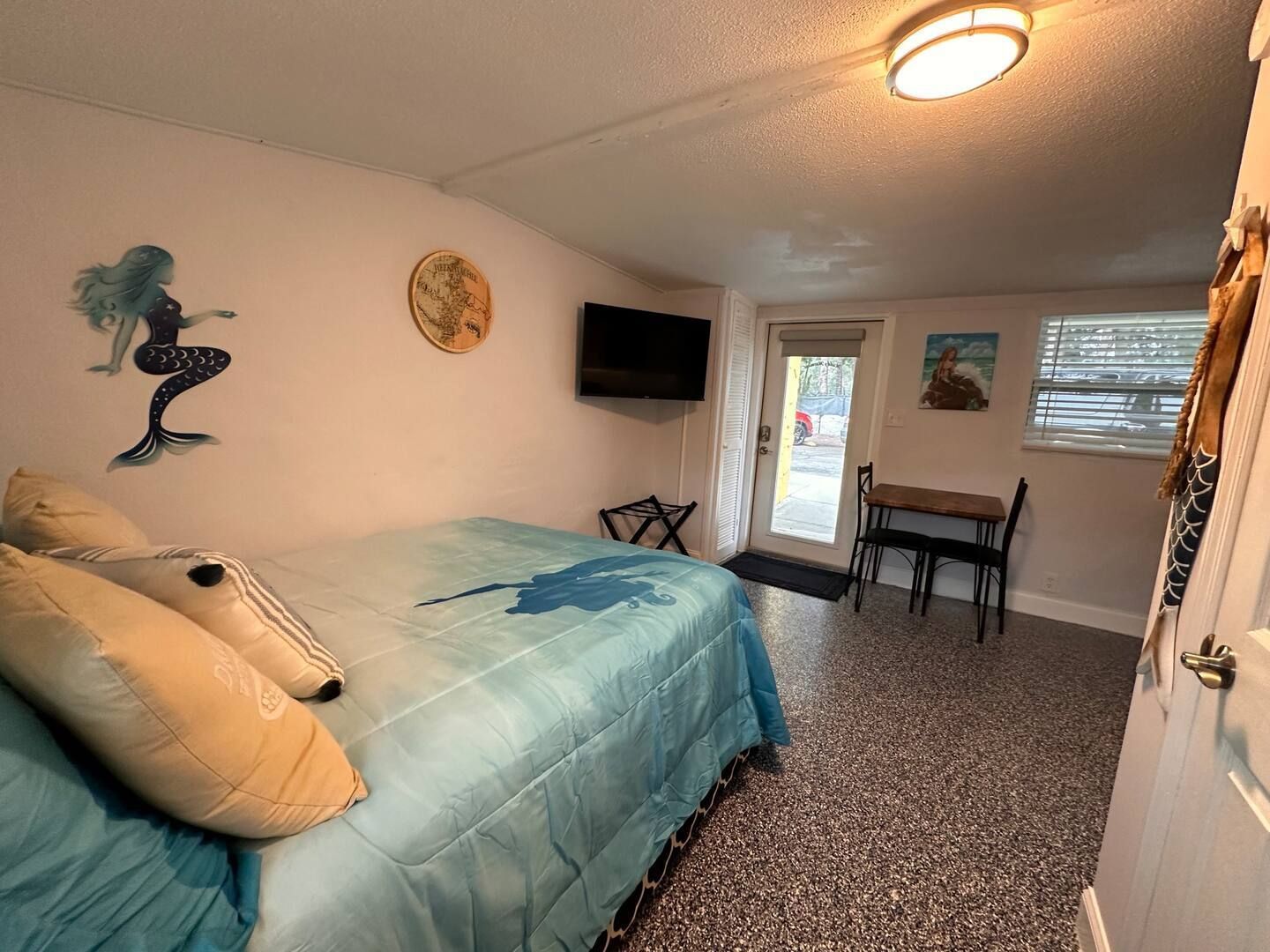 A bedroom with a bed , table and television.