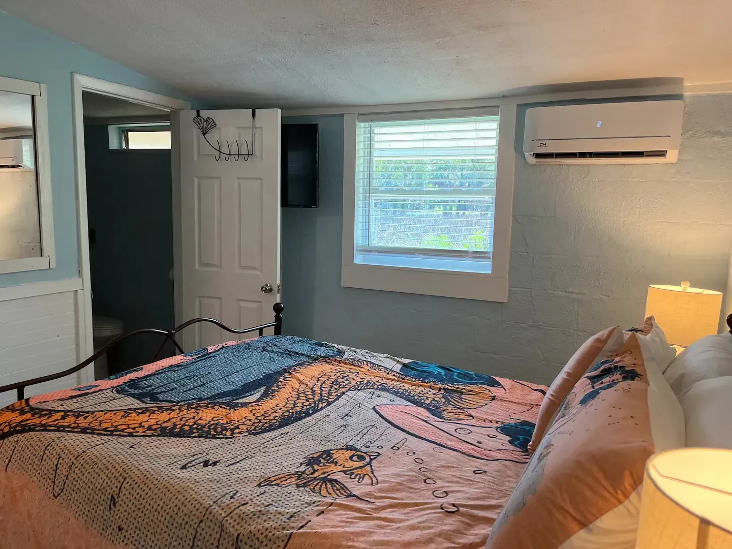 A bedroom with a large bed and a window.