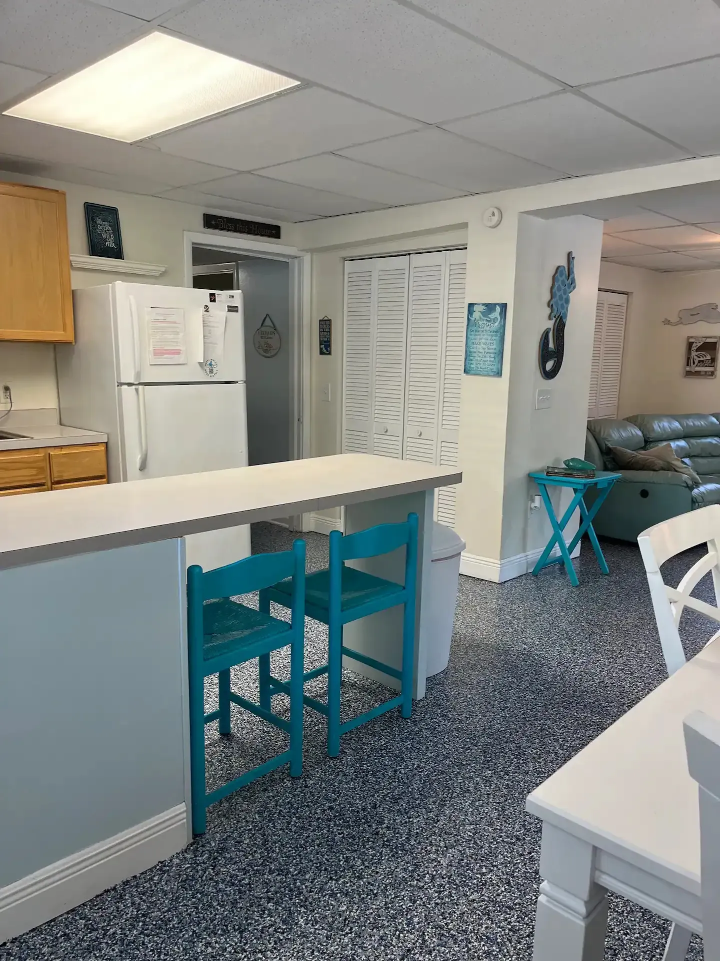 A kitchen with a refrigerator , sink , table and chairs.