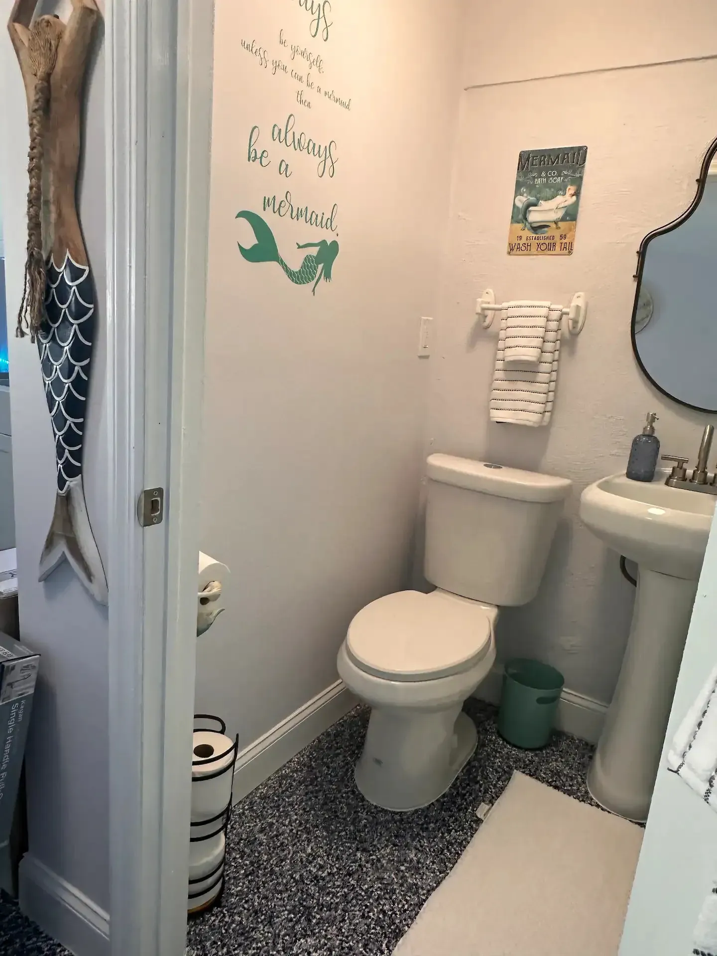 A bathroom with a toilet , sink and mirror.