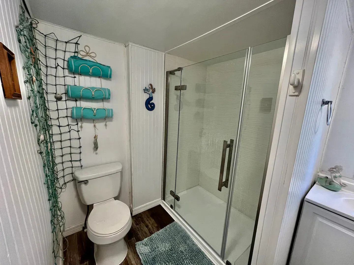 A bathroom with a toilet , shower and sink.