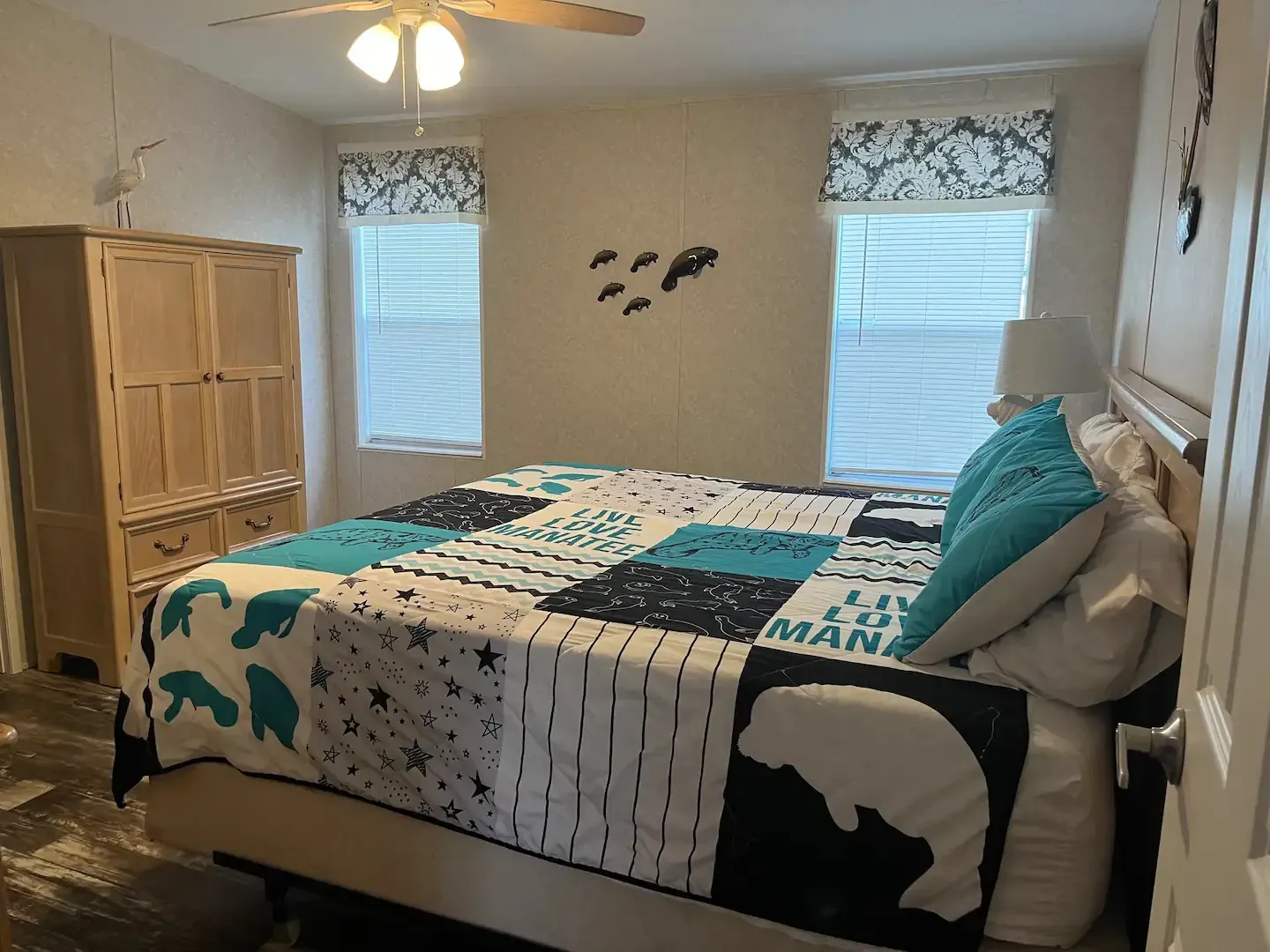 A bedroom with a king size bed and a ceiling fan.