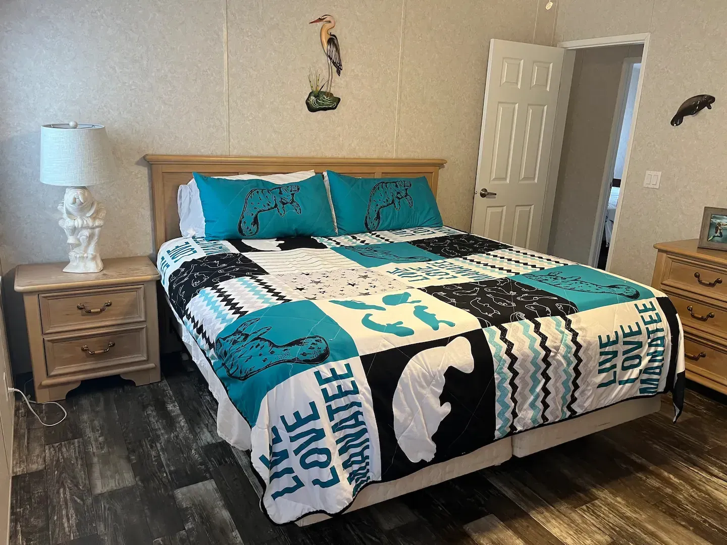 A bedroom with a bed , nightstand , lamp and dresser.