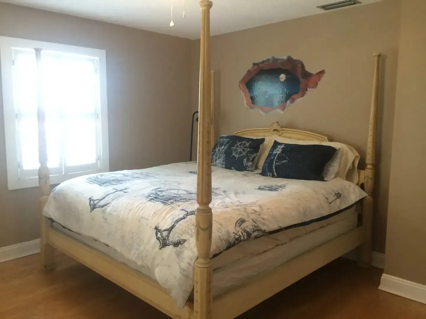 A bedroom with a four poster bed and a window.