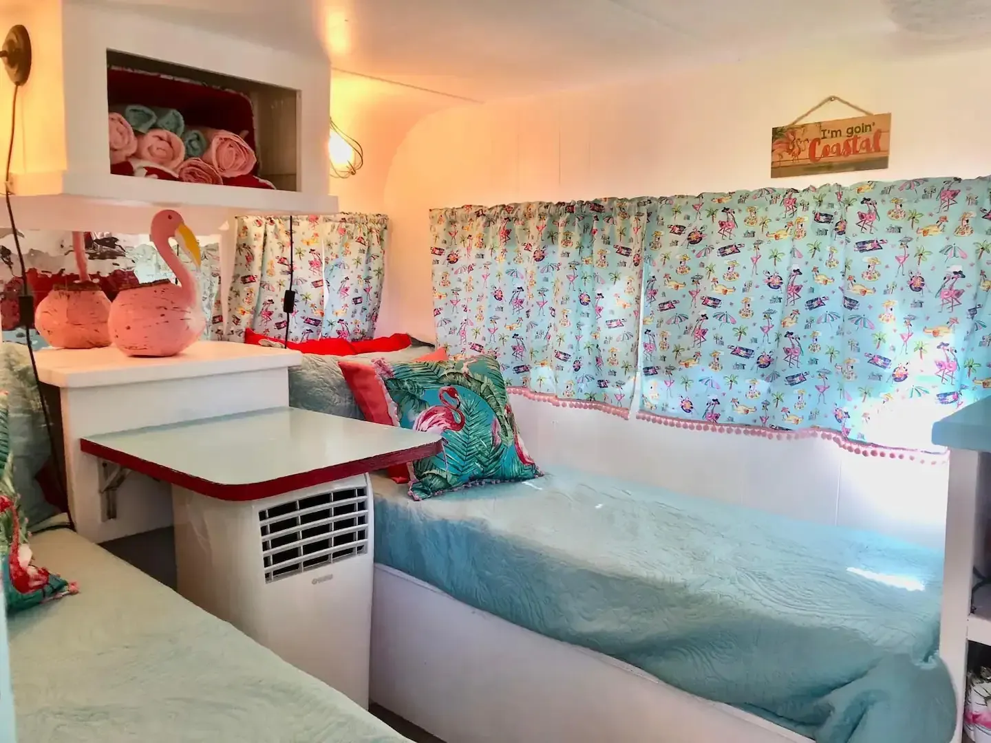 The inside of a camper with two beds and a table.