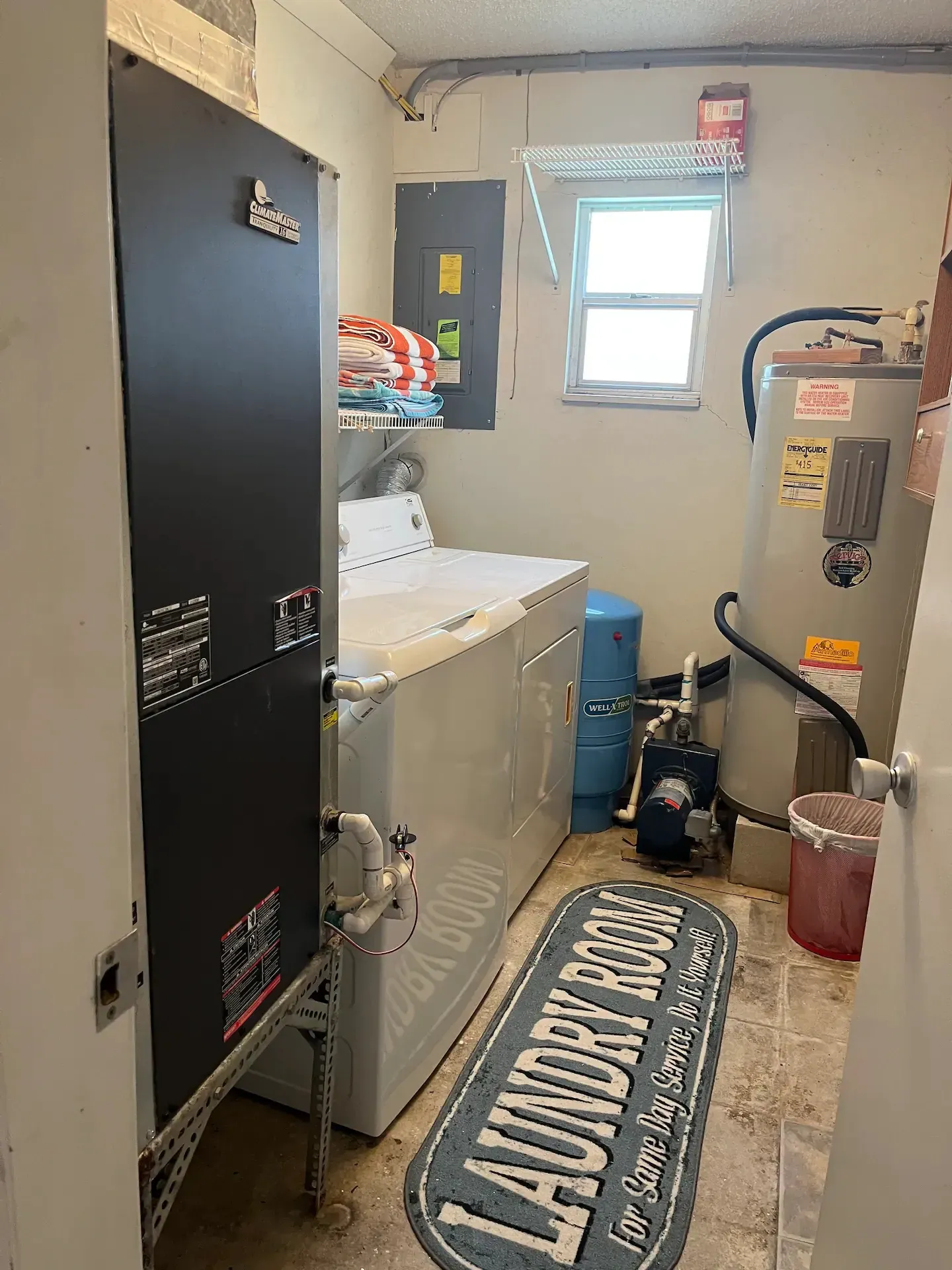 A laundry room with a washer and dryer and a water heater.